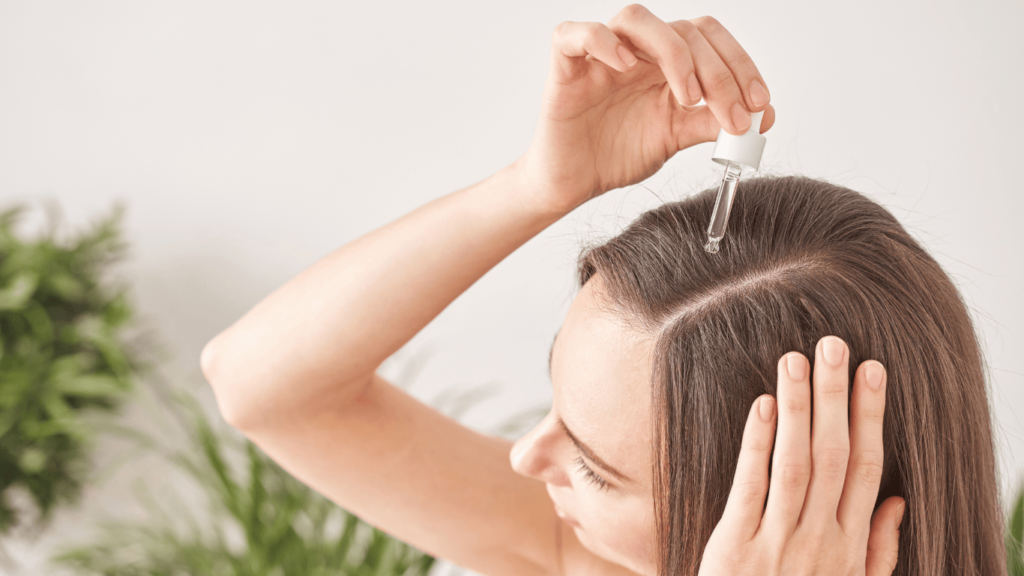 Mujer echándose sérum/aceite en el cabello